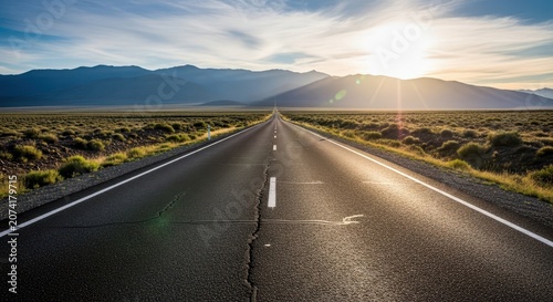 A long, empty asphalt road stretching through flat terrain towards distant mountains, symbolizing the vast range of a potential journey, future, outdoor, extent