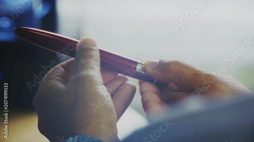 a close-up of both human hands holding an automatic insulin pen is captured