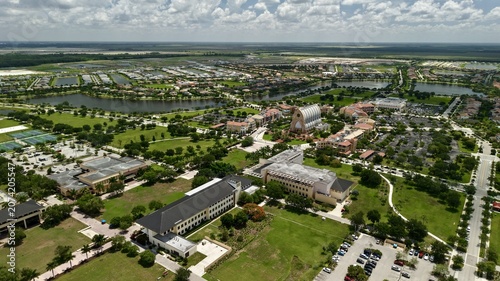 Aerial view of the Oratory of Ave Maria surrounded by campus buildings, green lawns, and residential neighborhoods in Ave Maria, Florida, United States.