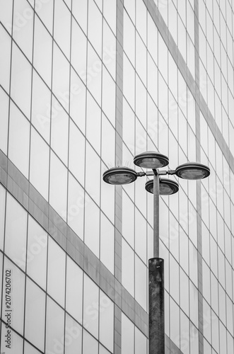 Modern street light against a glass office building facade