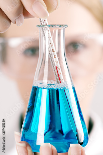 Scientist with a Conical Flask and Thermometor in a Laboratory, Close Up