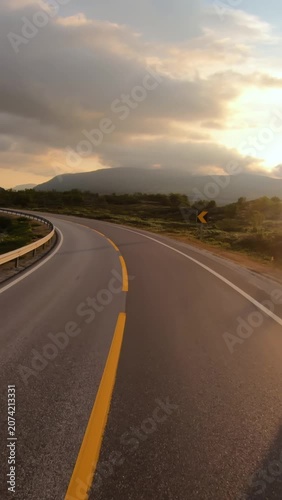 Empty road in Norwegian mountains at sunrise, vertical travel landscape.