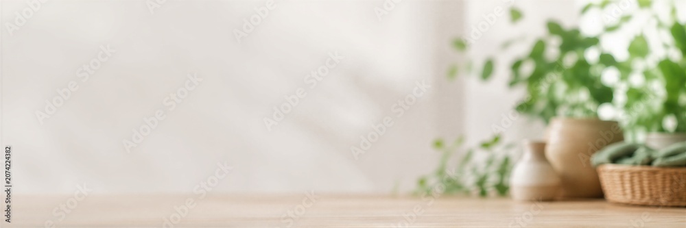 Fototapeta premium Wooden table with copy space and green plant in ceramic pot. Earth Day concept with natural elements and eco friendly lifestyle background. banner format