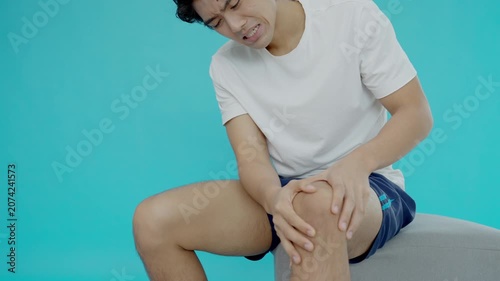 Asia male athlete or spot male having knee injury due to ligament inflammation, man knee pain due to exercise, massage, muscle relaxation, rheumatoid arthritis, gait disturbance, rheumatoid arthritis