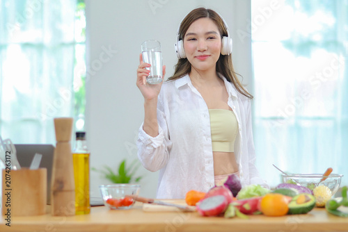 Tableau sur toile Asian women in good spirits hold glass clean water drink while cooking refresh themselves and ensure have enough water which helps keep bodies refreshed energetic beneficial their health