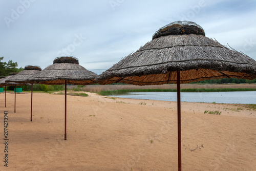 Straw umbrellas on the beach and a cloudy sky