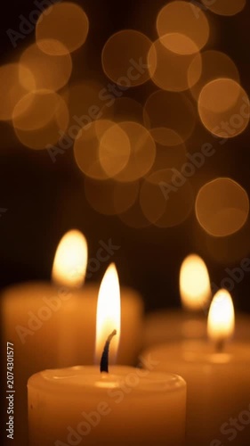 Flickering candle flames with warm bokeh background.
Close-up of burning candle flames flickering gently in the dark with soft golden bokeh background.