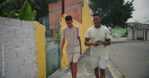 Konstfotografi Father of African descent sharing heartfelt talk with son while walking side by