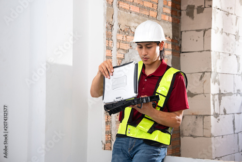 Construction worker using laptop at building site
