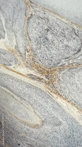 Close-up of naturally formed foam drifting slowly across the water surface, creating unique abstract textures and elegant flowing patterns for creative backgrounds and motion graphics.