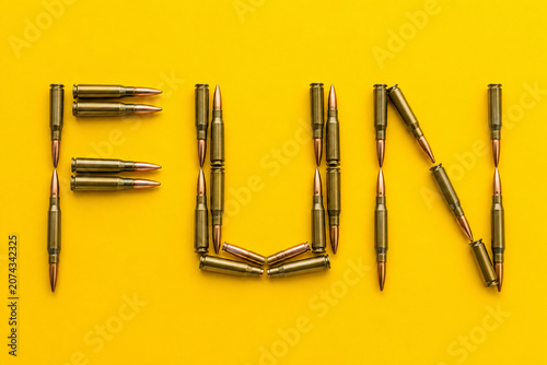 Fun word made from rifle cartridges on yellow background