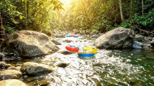 River tubing adventure in a tropical forest with colorful inflatable rings floating down a clear stream.