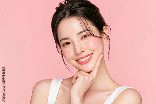 Skincare and beauty concept portrait of a charming smiling female model touching her chin