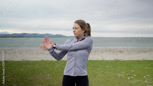 Fit woman stretching her arms before workout outdoors