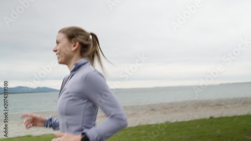 Fit woman jogging along the seaside on a cloudy day