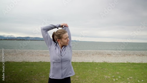 Athletic woman stretching arms before running workout