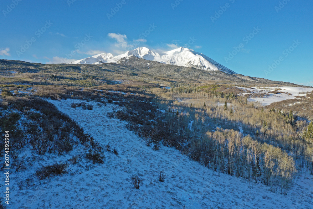 Obraz premium Aerial view of Mount Sopris and surrounding forest near Carbondale in Pitkin County, Colorado after light spring snowfall.