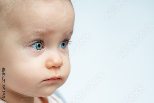 Photography One year old baby gazes to the side with curious eyes