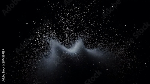 Tiny silver fragments bursting upward from a dark mass in dramatic light.