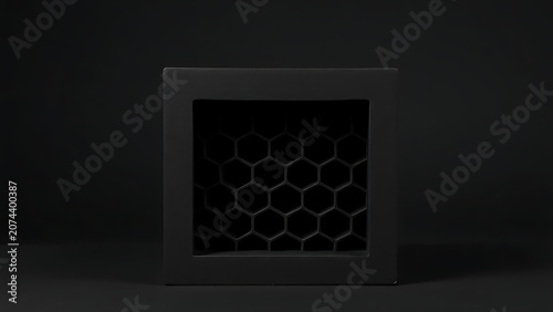 Black square block with honeycomb shadow pattern on plain surface.