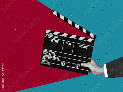 Hand holding a film clapboard on a red and blue artistic background