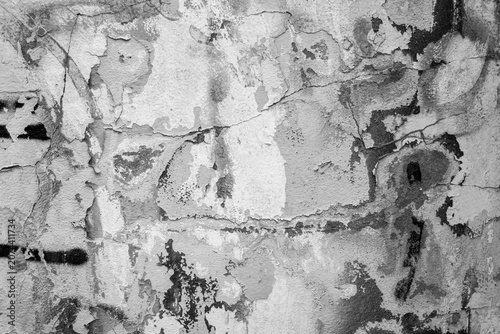 A black-and-white image of damaged graffiti on a building wall.