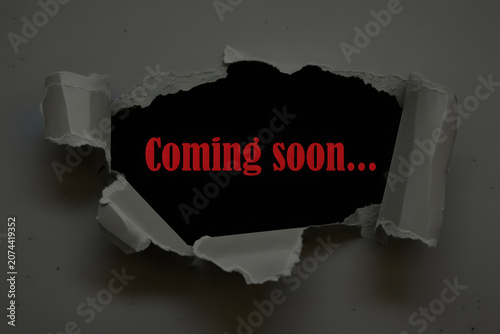 Coming Soon Message Revealed Through Torn Dark Gray Paper For Product Launch Marketing Announcement And Business Promotion Concept
