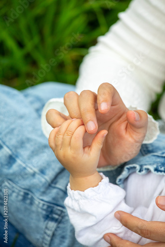 Mother and daughter holding hands outdoors close up