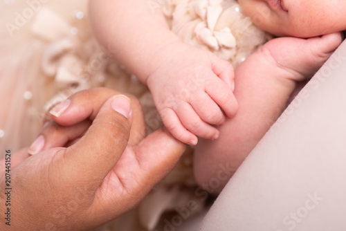 Little newborn baby hand being held by parent close up