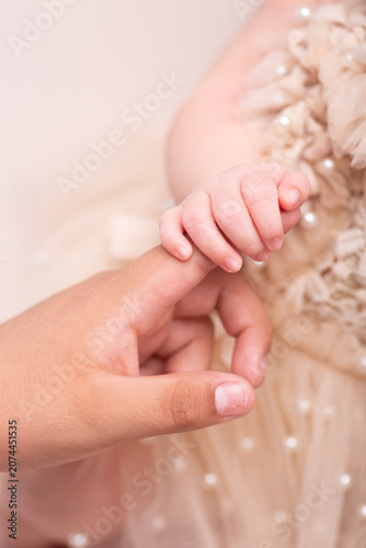Little newborn baby hand being held by parent close up