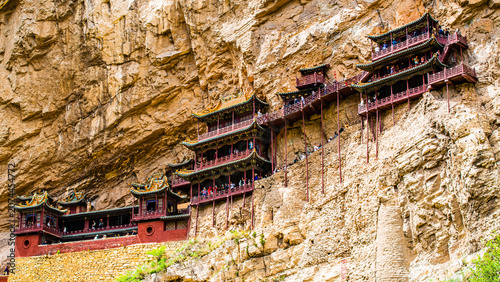 Shanxi, China - May 10 2026: The dramatic façade of Xuankong Temple clings to a sheer cliff, showcasing extraordinary ancient engineering and harmonious integration with the natural landscape