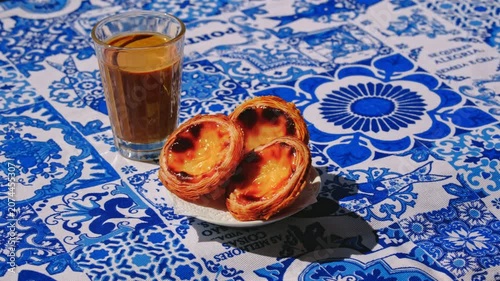 Hand placing three pastel de nata custard tarts on white plate on