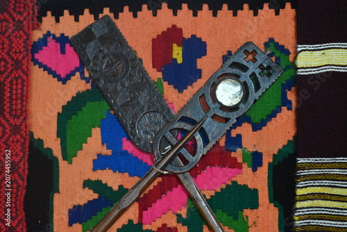 Photos Crossed wooden distaffs on a traditional handmade kilim rug.