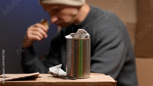 Canvastavla Man holding a piece of bread, reflecting on struggle and hardship while a donati