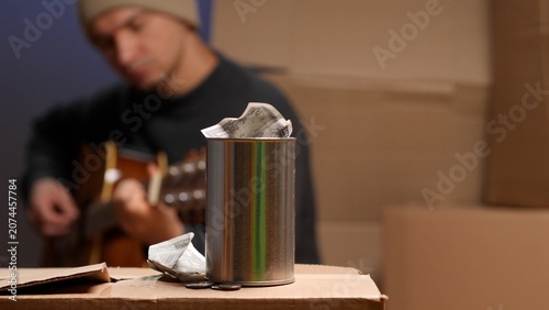 Konstfotografi Street musician playing acoustic guitar for donations while homeless, collecting