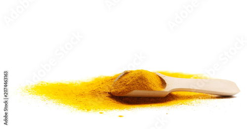 Turmeric scattered powder pile in wooden spoon isolated on white background, side view, clipping path
