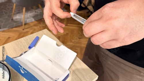 Close up of adult hands opening sterile medical package with syringe, clean indoor workspace setting, careful preparation for injection, healthcare safety and hygiene