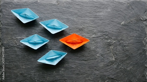 Paper boats on slate leadership and individuality concept