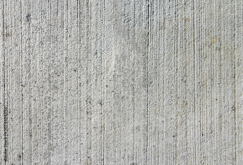 Brushed concrete surface. Textured grey cement background with vertical lines from construction finishes.