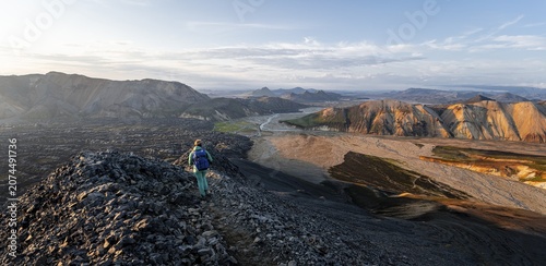 Hiker on the Laugavegur trekking trail, Laugavegur trekking trail, Dramatic volcanic landscape, Colourful erosion landscape with mountains, Lava field, Landmannalaugar, Fjallabak nature reserve, Suðurland, Iceland