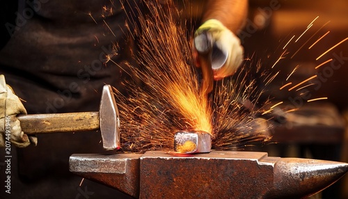 hot metal being hammered on anvil in blacksmith workshop glowing sparks flying as metal is shaped with intense heat and force