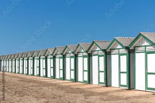 фотографія The wooden beach huts on a sandy shore under a clear blue sky on island of Lido
