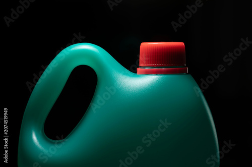 Green plastic bottle with red cork on black background
