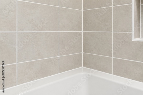 Bathroom tile grid with fresh white waterproof caulking lines.