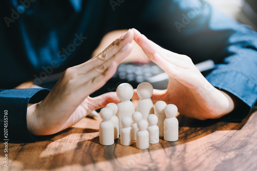 Family protection concept. Hands covering family figures for insurance safety, financial security, care, and future planning