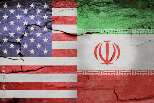 US and Iran flags painted on cracked concrete wall. United States and Iranian national symbols on damaged cement texture, concept of geopolitical conflict, sanctions or diplomatic crisis