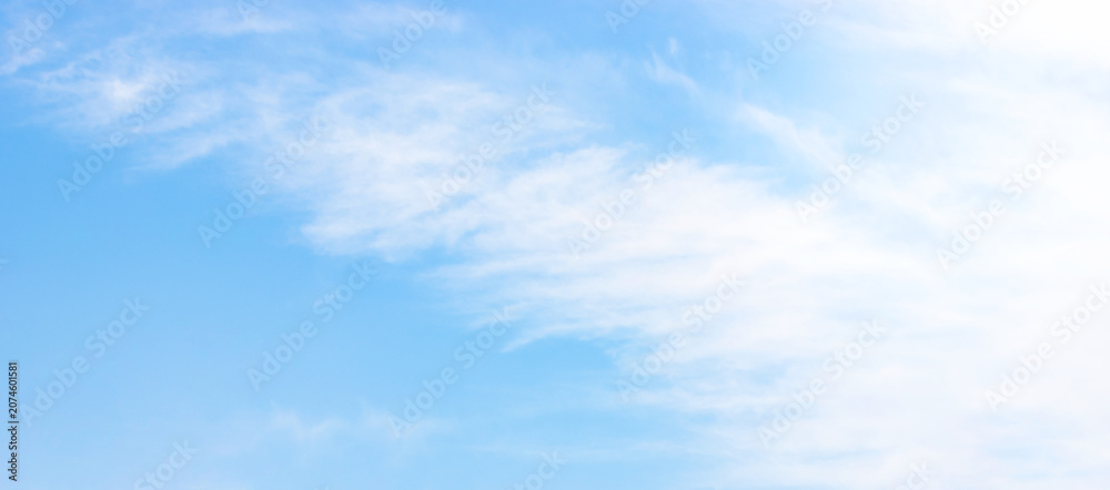 Obraz premium Beautiful bright blue sky background texture with soft light white cirrus clouds on a clear sunny day full frame panoramic abstract backdrop template with copy space for graphic design.