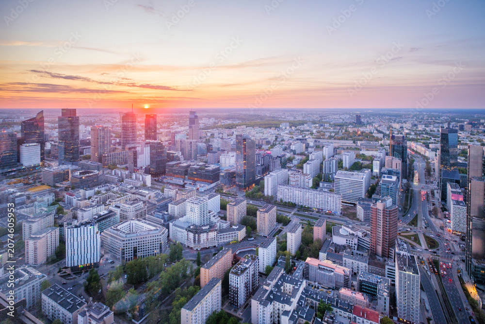 Fototapeta premium High viewpoint over the Warsaw skyline in Poland with skyscrapers, cityscape layers, city depth, sunset color and dramatic sky