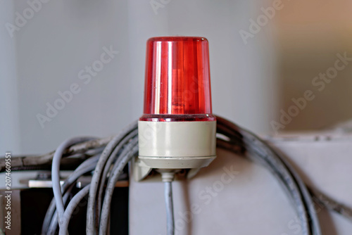 Tableau sur toile A close up shot of a red plastic warning strobe light or emergency beacon mounted on machinery with bundled grey electrical wires