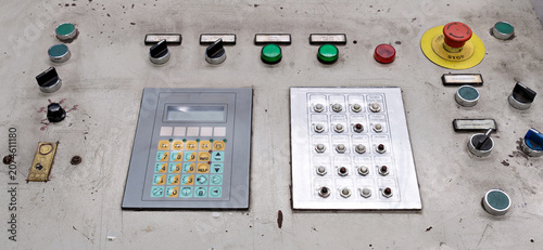 Obraz na płótnie Detailed view of an industrial automated system control board showing a digital display module, custom push-button array, and safety control elements inside a manufacturing plant